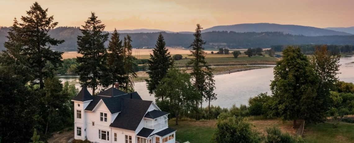 Stunning white Victorian home on the river with gorgeous mountain and prairie views and a fabulous treed lot under a colorful sky